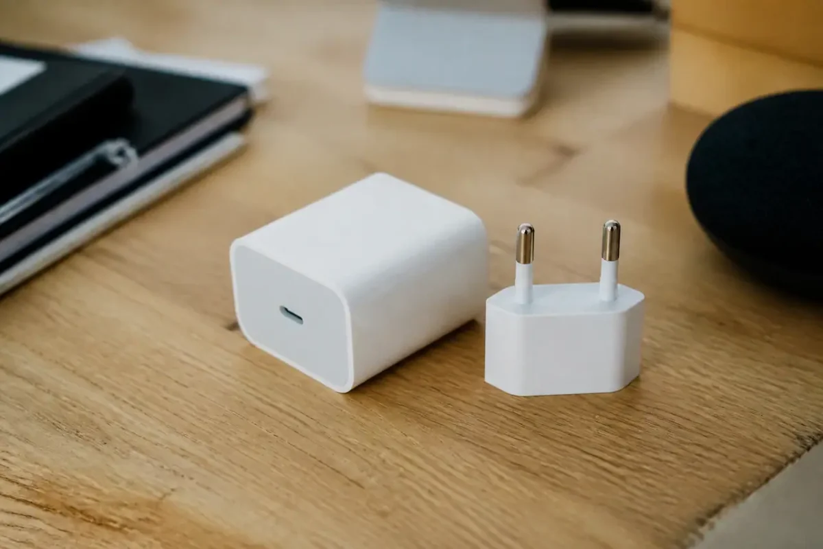 Chargeur blanc et adaptateur Europlug sur un bureau